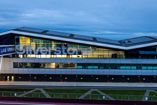 The Silverstone pit building lit up at twilight, ideal for motorsport, travel, and architecture themes.