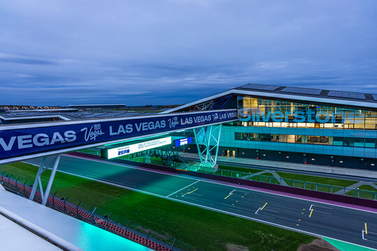 The Silverstone pit building lit up at twilight, ideal for motorsport, travel, and architecture themes.