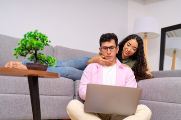 Young couple connecting at home using laptop