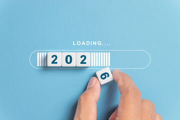 Hand putting dice for loading progress from 2025 to 2026 to countdown merry christmas and happy new...