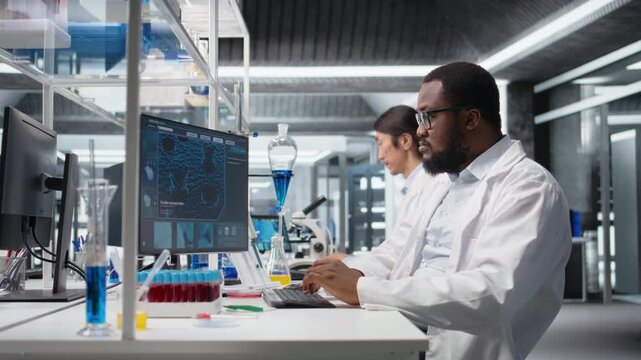 Molecular biologist uses computer program displaying DNA data, removing eyeglasses. African american man confused by bioinformatics genomics software analysis on PC in lab, camera A