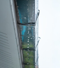 Leaking galvanized roof gutter joint with water dripping from worn-out seal