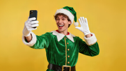 Holiday performer takes a selfie while dressed in a festive elf costume against a bright yellow background