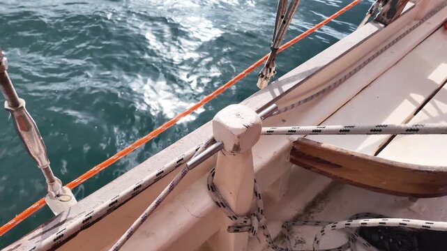 Marine life. A man quickly tightens the rope and ties it securely to set sail.