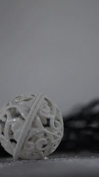 Una toma de cerca de una bola de navidad blanca rodeada de luces de varios colores con un fondo desenfocado. Decoraci&oacute;n de navidad y fin de a&ntilde;o