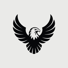 A majestic black eagle soars with its wings spread wide against a light gray backdrop, showcasing its power and grace in a striking silhouette isolated on white background