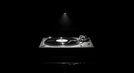 A turntable with a vinyl record is illuminated by a spotlight against a dark background.