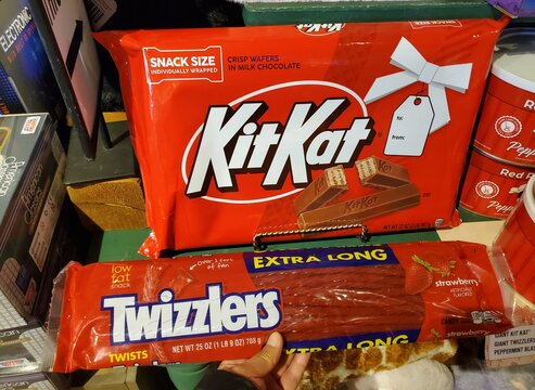 Dickinson, New York, U.S - Oct 19, 2025 - A large bag of snack-size Kit Kat crisp wafers in milk chocolate displayed above an extra-long package of strawberry Twizzlers twists.