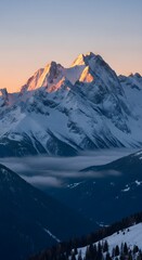 Obraz premium Majestic snow capped mountains bathed in golden sunrise light above misty valleys