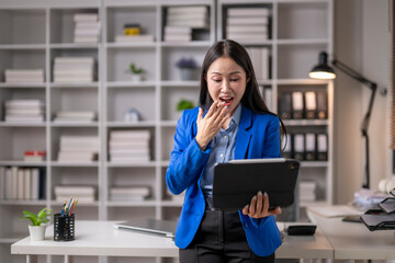 Obraz premium Businesswoman shocked by news on tablet