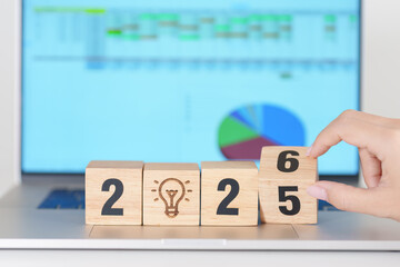 2025 end year to Happy New Year 2026 block with lightbulb icon against computer laptop background....