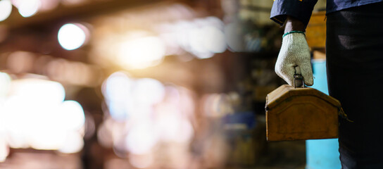 Close up hand holding toolbox in industrial factory with copyspace.