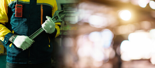 Close up mechanic holding wrench in industrial factory with copyspace.