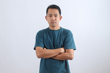 Confident young Asian man with arms crossed on white background.