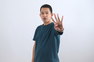 Asian man showing four fingers hand gesture counting on white background.