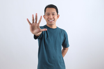 Smiling Asian man showing number five or stop hand gesture.
