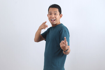 Happy Asian man pointing finger at camera, choosing you. Excited male model smiling.