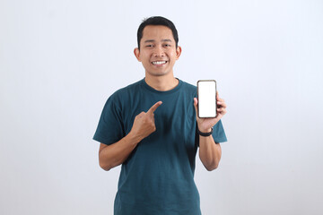 Happy Asian man pointing at blank phone screen mockup for advertisement