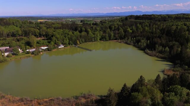 Drone panorama of Moorweiher Esssee in Seewiesen, Poecking, Bavaria, Germany. Surrounded by peatland, wetlands, and rare flora like orchids in springtime. Environmental conservation in Oberbayern