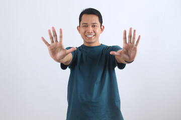 Smiling Asian man showing ten fingers stop hand gesture