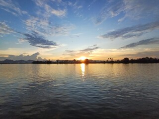 Naklejka premium Golden Sunset Reflections Over Peaceful River Waters