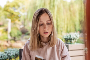 Young woman reading outdoors in a garden setting