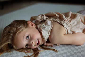 Smiling young girl lying on a floor looking at the camera