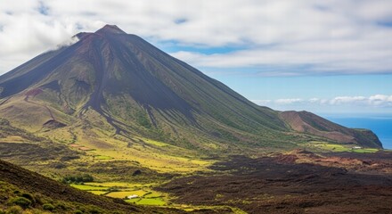 Fototapeta premium Volcano Vista: A majestic volcano rises against a backdrop of a partially cloudy sky and rolling hills, a panorama of natural grandeur.