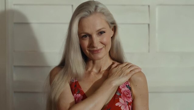 self-assured older female model in her seventh decade  posing in undergarments for a studio portrait  conveying happiness through her