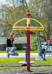 boy hanging from swinging merry go round