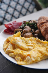 Tasty breakfast: eggs, croissant, and veggies