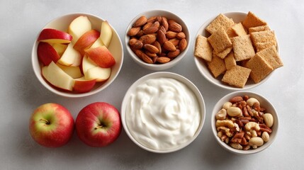Healthy Snack Ingredients Arranged in Bowls Featuring Fresh Apples, Greek Yogurt, Nuts, and Whole Grain Crackers on a Light Background