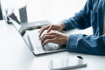 Man working by using a laptop computer Hands typing on keyboard. writing a blog. Working at home...