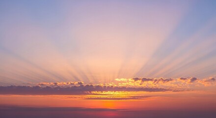 A stunning high-resolution photograph of a partly cloudy sky at sunrise. The horizon glows with soft pink, peach, and golden tones blending into a light blue upper sky. Fluffy, diffused clouds catch t