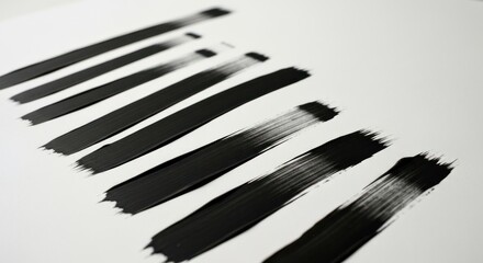 Eight black brushstrokes in diminishing size, angled on white