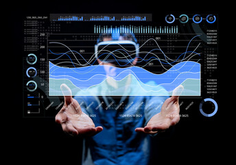 Man in virtual reality goggles interacting with data visualization and graphs in a dark environment, showcasing innovative technology and digital analytics