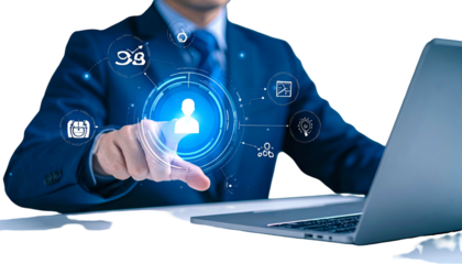 A man in a suit interacting with a glowing user interface while sitting at a laptop