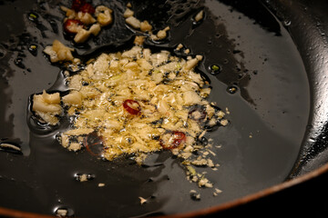 ニンニクと唐辛子をオリーブオイルで炒める様子