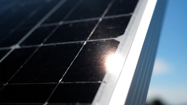 Close-up of solar panel corner with sunlight reflection