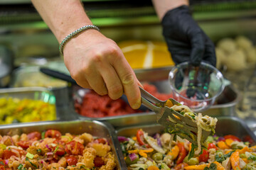 Colorful ready-to-eat salads arranged in trays at gourmet rotisserie salad bar