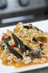 Close-up of delicious fish pasta cooked with fresh tomatoes and garlic sauce on a dish