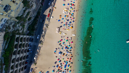 Aerial overhead view of Tropea beach with turquoise sea and sun umbrellas in Calabria