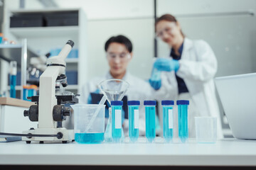 Fototapeta premium Team of Asian scientists working in modern laboratory equipped microscopes, chemical reagents, conducting advanced research in biochemistry, molecular biology, microbiology, pharmaceutical innovation
