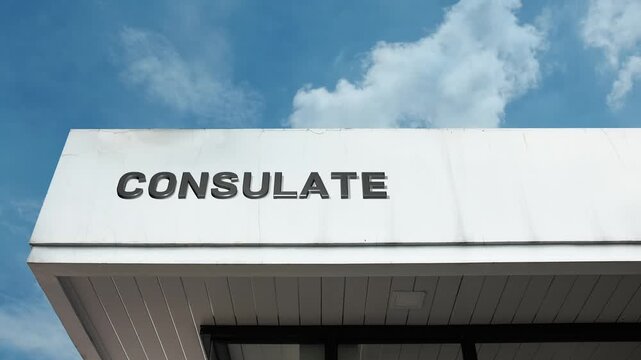 Consulate word sign displayed on the exterior of a diplomatic building under a clear blue sky, symbolizing international relations, consular services, diplomacy, and foreign affairs support