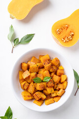 Roasted butternut squash pumpkin in a bowl on white background, Autumn homemade food, top view