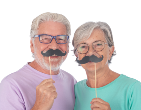 A joyful couple poses with playful mustache props, showcasing a fun and lighthearted moment against a solid black background.