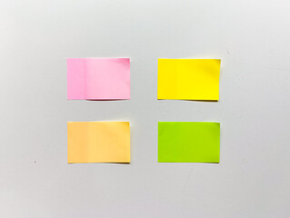 Four brightly colored sticky notes (pink, yellow, orange, green) on a clean background. Concept for categorization, data organization, and project iteration.