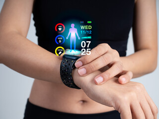Close-up of woman in black sport bra using smart fitness watch on wrist with holographic health data display, tracking steps, heart rate, and calories. Concept of wearable technology and health care.