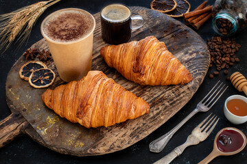 Fresh croissants in the plate at the hands of two women