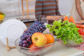 Asian healthy pregnant mother and children lifestyle bonding togetherness, pregnancy woman cutting tomatoes with naughty little daughter, motherhood family happy activities together in kitchen